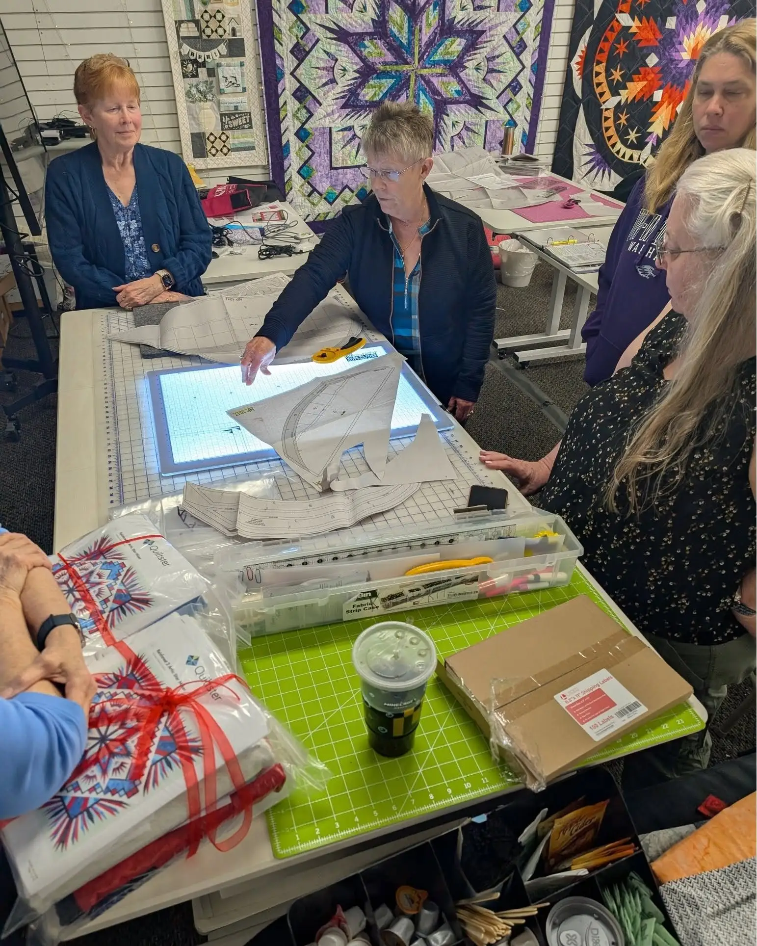 Students gathered around a light box while working on foundation paper piecing