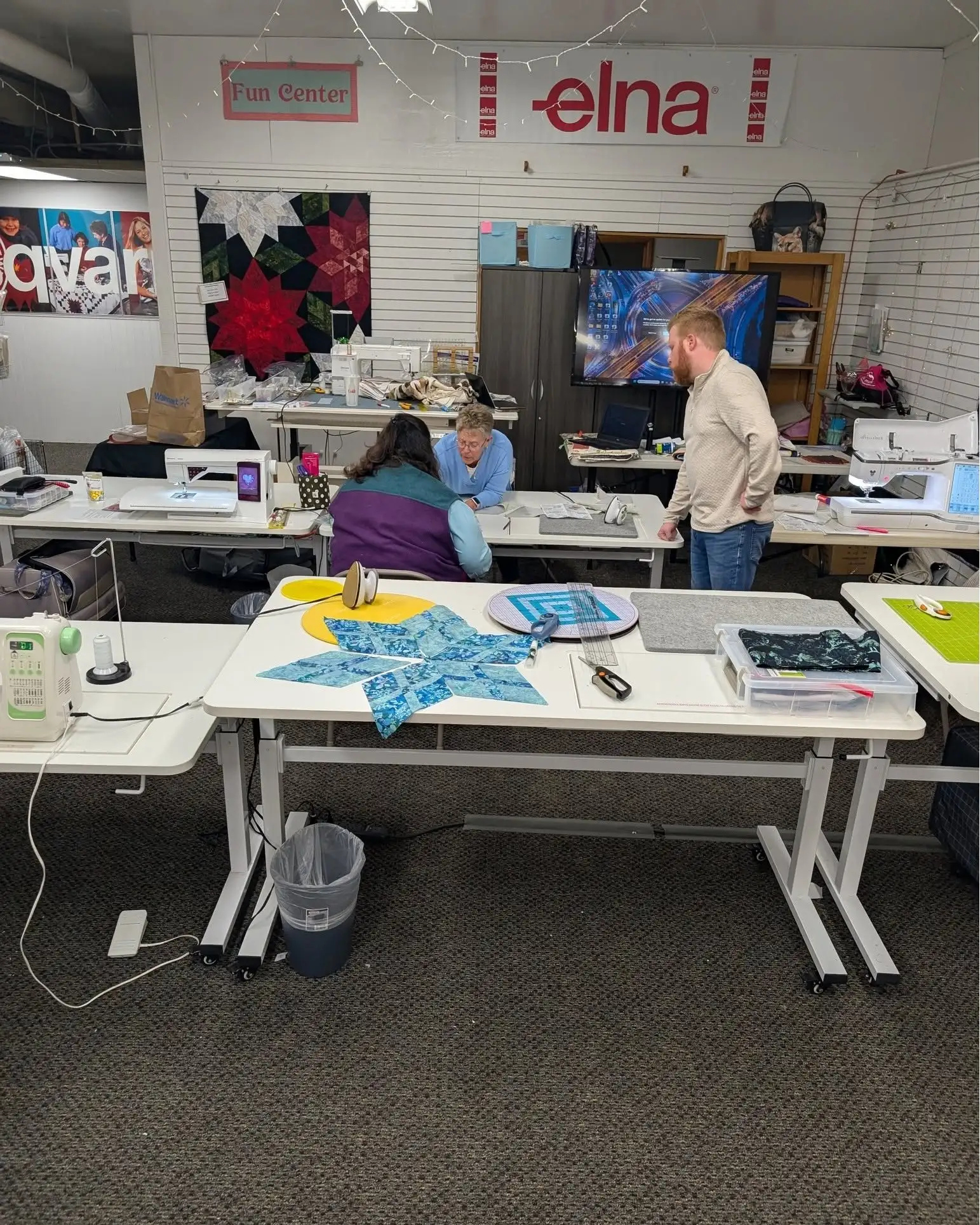 A quilting classroom set up with sewing machines and a paper pieced star on the table